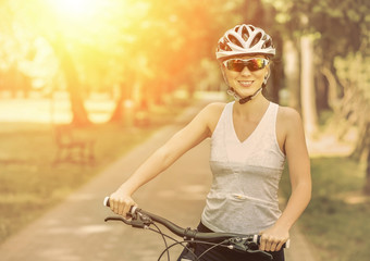 Portrait of beautiful woman on the bicycle in the park.