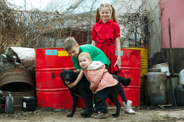 children play at dump with dog