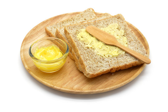 Isolated whole wheat bread and butter in a wooden bowl