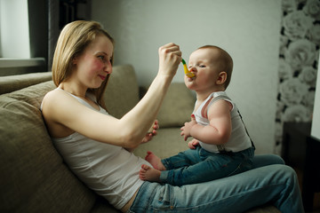 mother feeding baby with a spoon