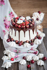 Cake decorated with chocolate, meringues and fresh berries