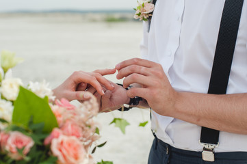 Groom wears the ring on the finger of the bride