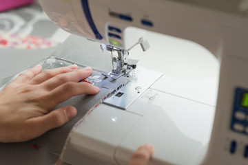 close woman hands sewing on sewing machine