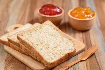 Fototapeta na wymiar slices bread with jam on wooden table