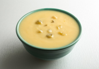 Bowl of cream of celery soup white cutting board