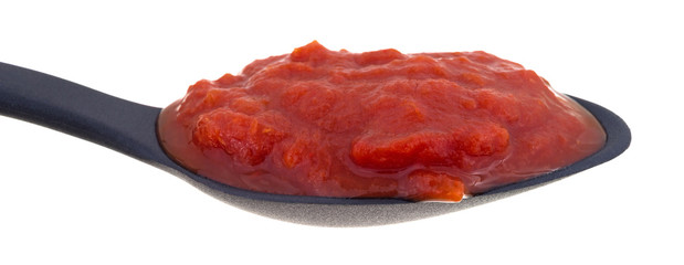 Spoon filled with crushed tomatoes and jalapeno peppers