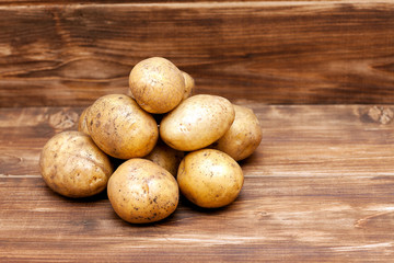 Fototapeta na wymiar Potatoes on wooden background