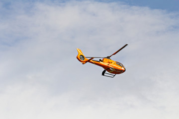Civilian helicopter flying in the sky with blur propeller