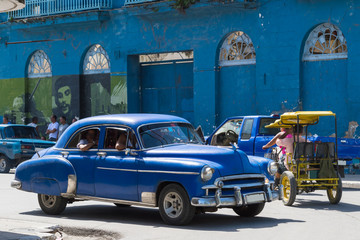 Kuba auf der Strasse fahrender blauer amerikanischer Oldtimer im Inneren des Landes