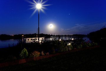 Noc nad jeziorem, księżyc, latarnia.