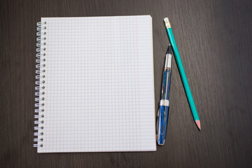 blank notebook with pen and pencil on wooden table, business con