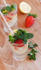 homemade lemonade with mint and strawberries on a wooden