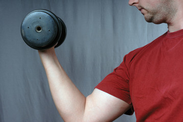 Young man holding iron dumbbell