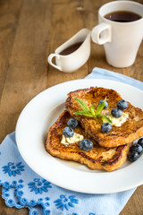 French toasts with fresh blueberries and maple syrup