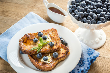 French toasts with fresh blueberries and maple syrup