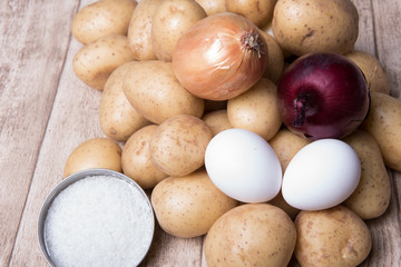 onions, eggs and potatoes on a wooden background