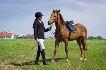 Beautiful young girl jockey talks with her horse