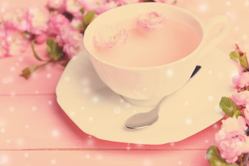 Cup of tea and beautiful fruit blossom on table