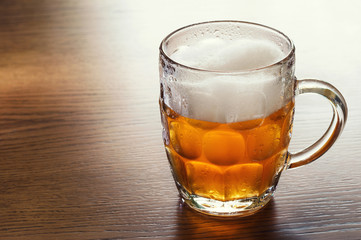Mug of beer on wooden table