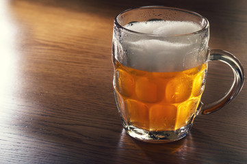 Mug of beer on wooden table