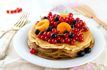 Pancakes with berries and fruits: apricot, red, blackcurrant