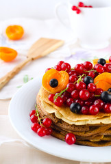 Pancakes with berries and fruits: apricot, red, blackcurrant