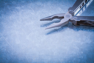 Stainless nippers on scratched metallic background construction 
