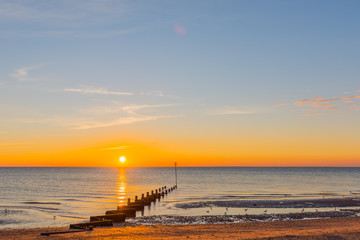Fototapeta na wymiar Setting sun over Hunstanton beach Groyne.