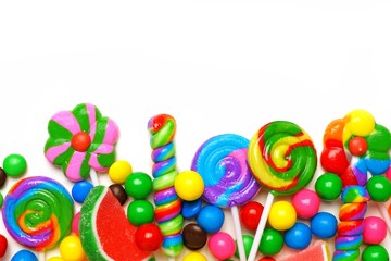 Bottom border of an assortment of colorful candies against a white background