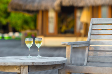 Two glasses of tasty white wine at sunset on wooden table