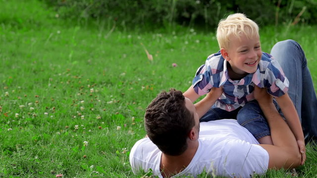 Father and son playing on the grass in park
