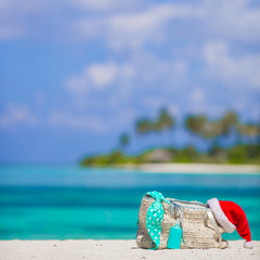 Beach bag, swimsuit, sunscreen bottle and Santa Hat on white