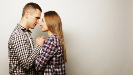 lovely happy couple hugging over grey background.