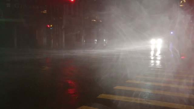Car driving through heavy typhoon rain