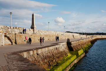 Unidentified people walk along Dun Laoghaire's East pier, Ireland.