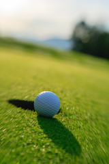 Golf ball about to drop in the hole.