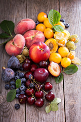 Naklejka na ściany i meble Fresh stone fruits on wooden table