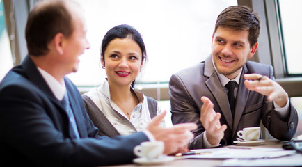 Portrait of smart business partners communicating at meeting