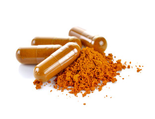 Tumeric powder capsules on white background