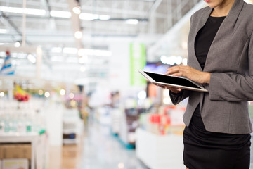 Woman using tablet in shopping mall.