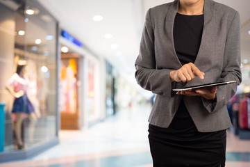 Woman using tablet in shopping mall.