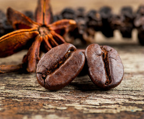 Coffee grains and green leaf on grunge wooden background