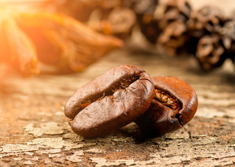 Coffee grains and green leaf on grunge wooden background