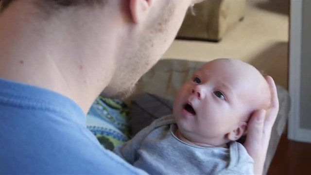 Handsome newborn boy looking at father