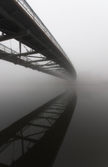 Bernatka footbridge over Vistula river in Krakow in heavy fog.