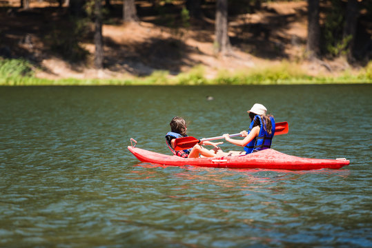 Two girls at the lake doing water sports.