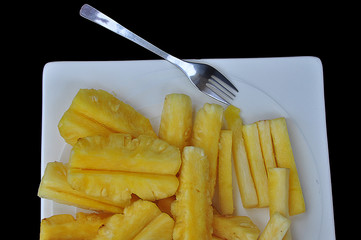 Cut pineapple on white dish
