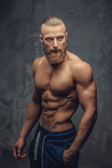 Obraz na płótnie Canvas Muscular man with beard showing his great body.