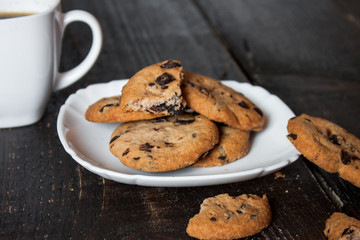 кофе в белой чашке с печеньем на деревянном столе