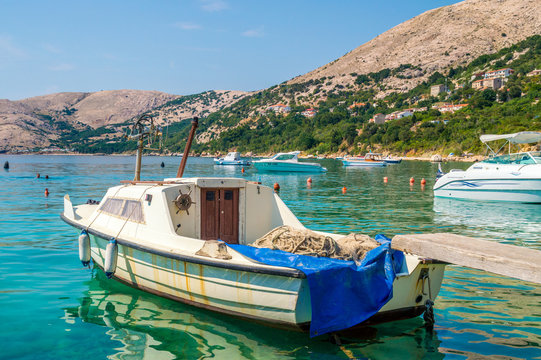 An old rusty fisherman's boat tied on the dock on the Adriatic s